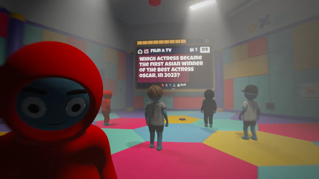 A contestant in a red hoodie looks at the camera while the other players wait under a Film & TV question on the big monitor